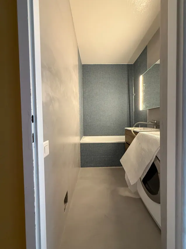 Salle de bains avec sol et parois d’aspect minéral