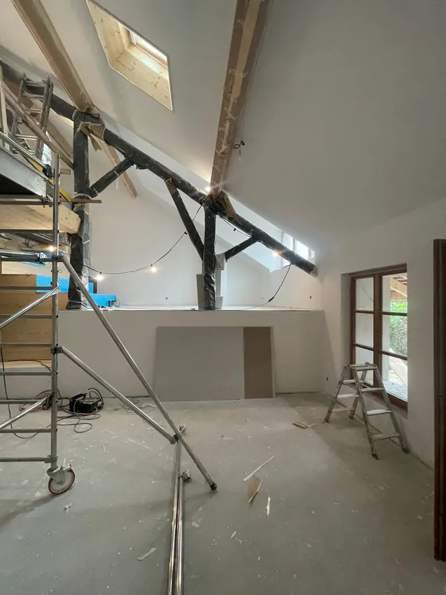Grand espace en cours de travaux, murs préparés et échafaudage
