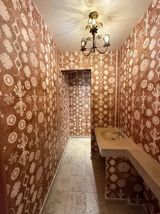 Petite pièce revêtue d’un papier peint aux motifs cuivrés