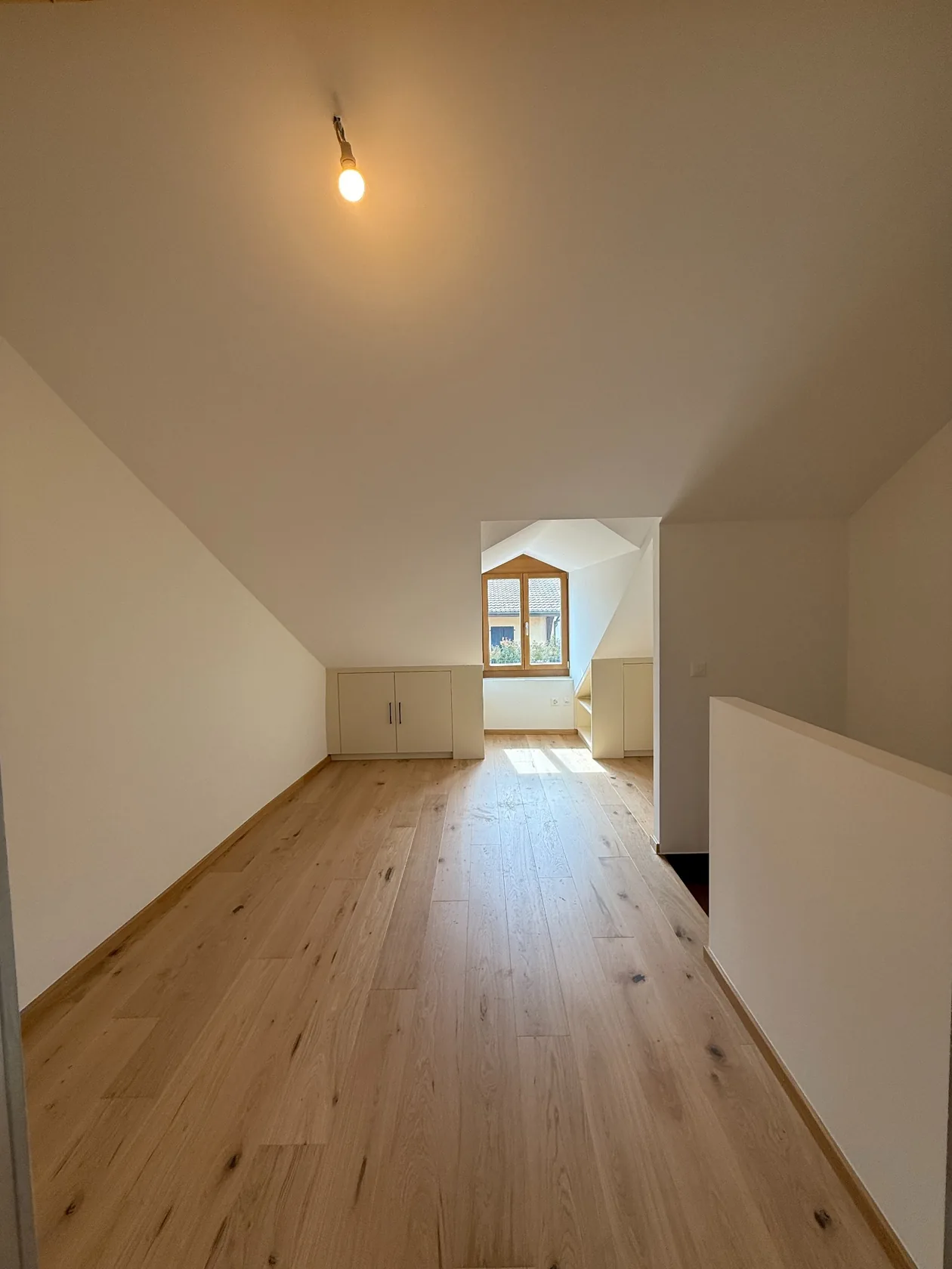 Combles rénovés, sol en bois et surfaces blanches
