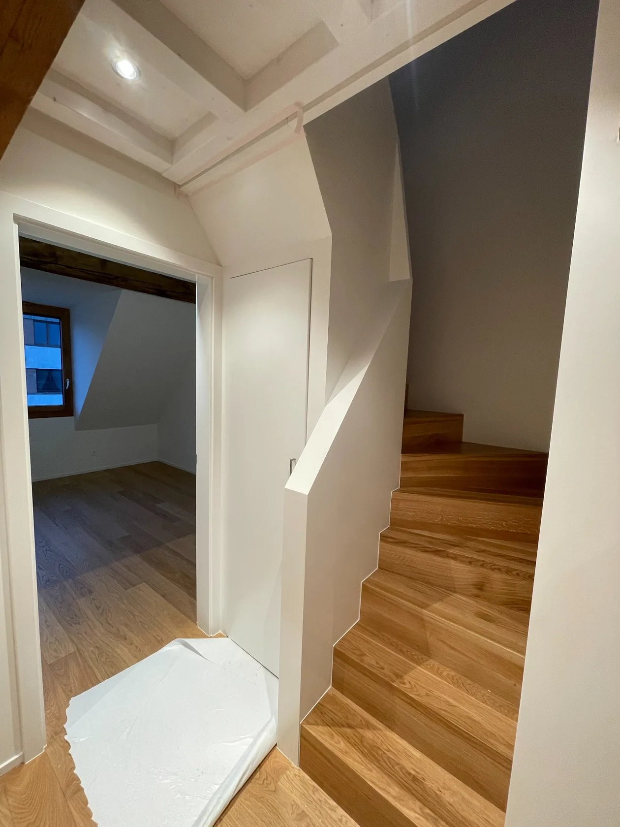 Escalier en bois, murs clairs et détail de finition intérieure