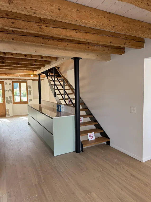 Intérieur à poutres apparentes, cuisine et murs clairs