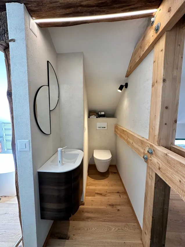 Coin WC sous poutres apparentes, surfaces claires